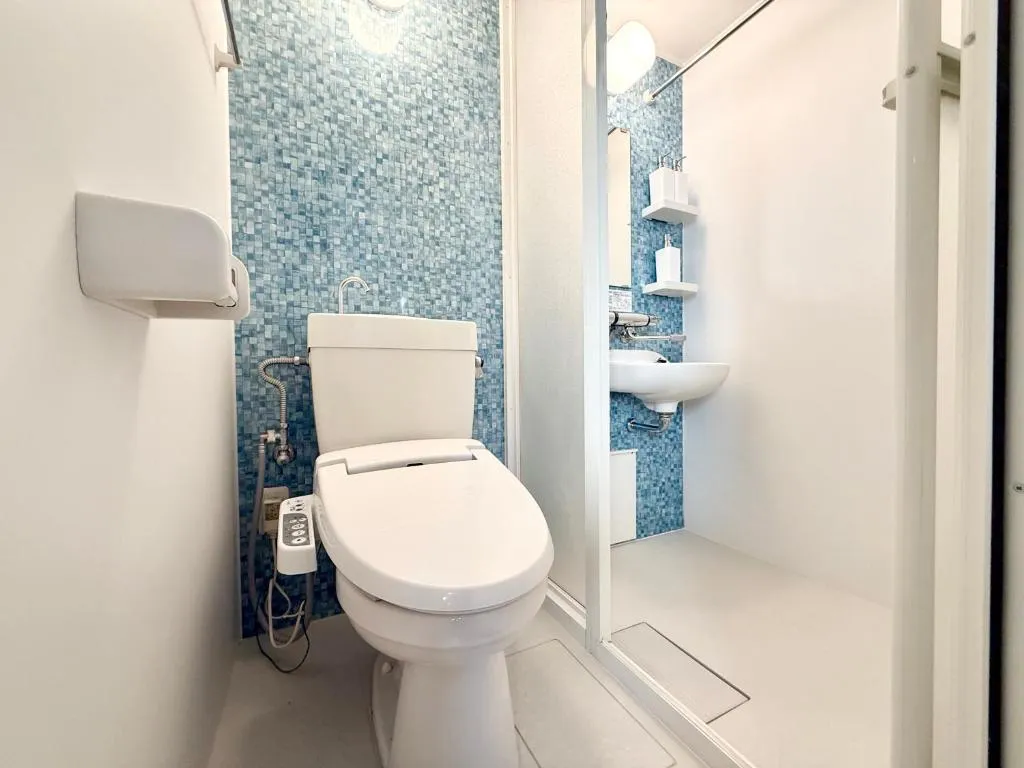 Modern bathroom at 99Base Yotsuya with toilet and shower area