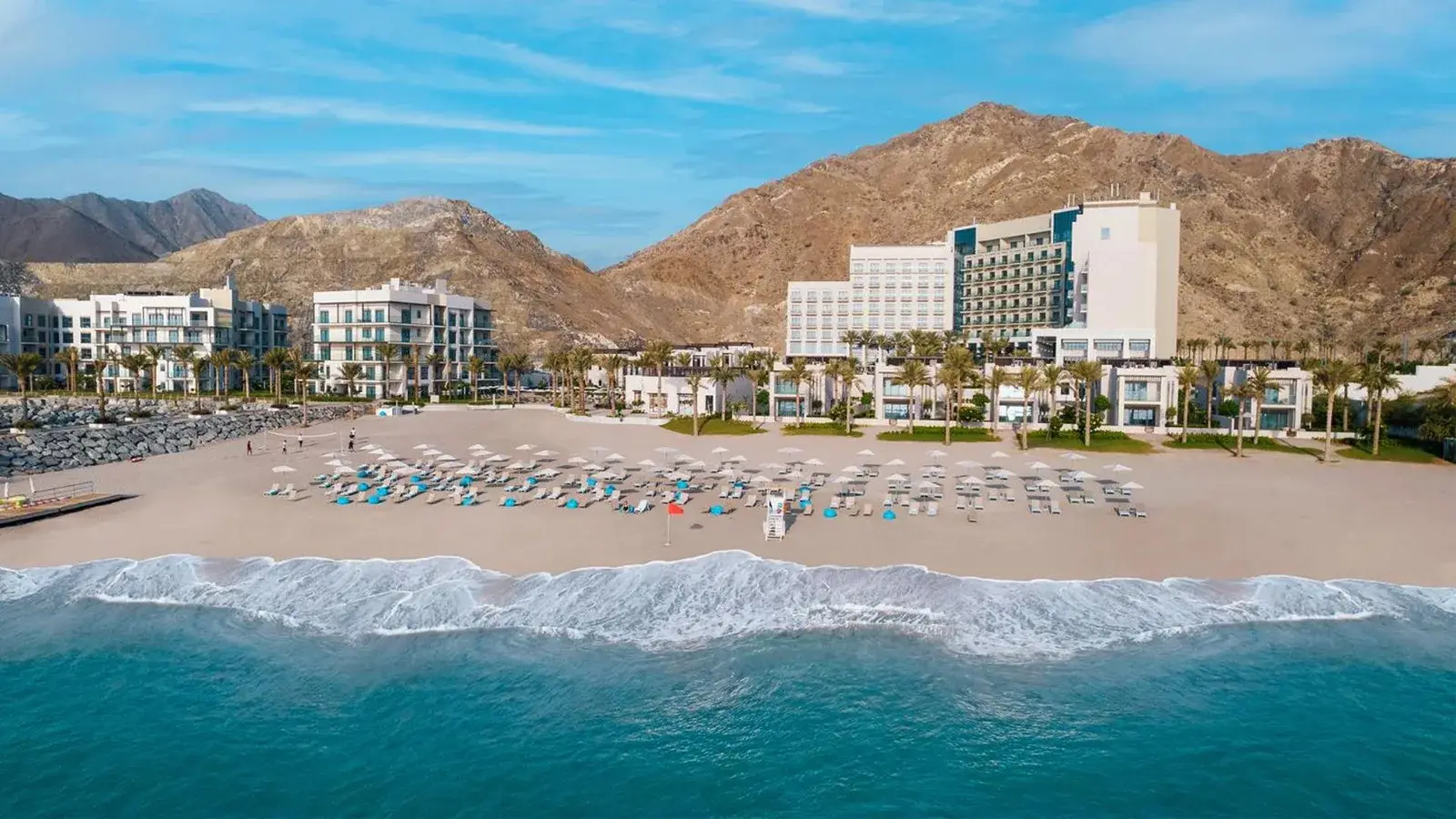Address Beach Resort Fujairah with a beautiful beach and mountains in the background