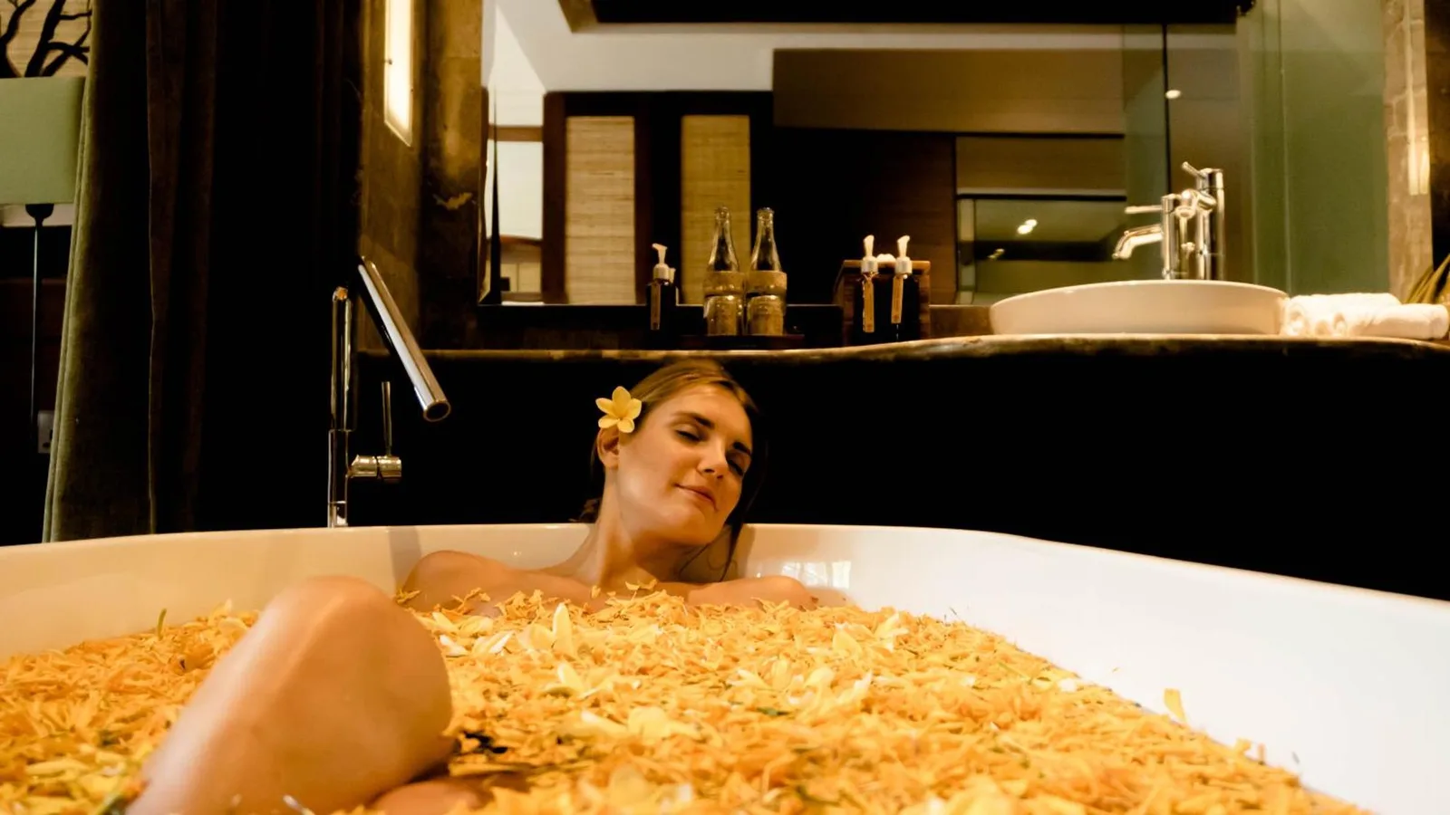 Baignoire de luxe avec des pétales de fleurs à l'Adiwana Resort Jembawan à Ubud