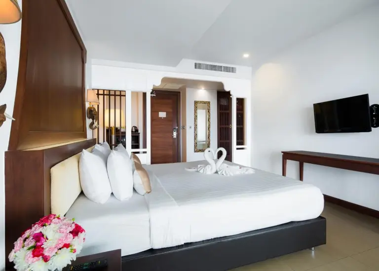 Modernes Eckschlafzimmer im Aiyara Grand Hotel Pattaya mit Bett, Schreibtisch und wandmontiertem TV