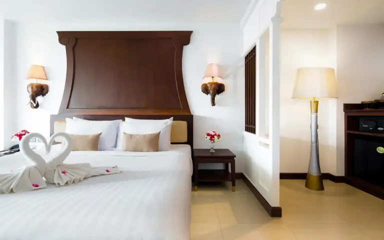 Elegantes Schlafzimmer im Aiyara Grand Hotel Pattaya mit Kingsize-Bett, Nachttisch und Stehlampe