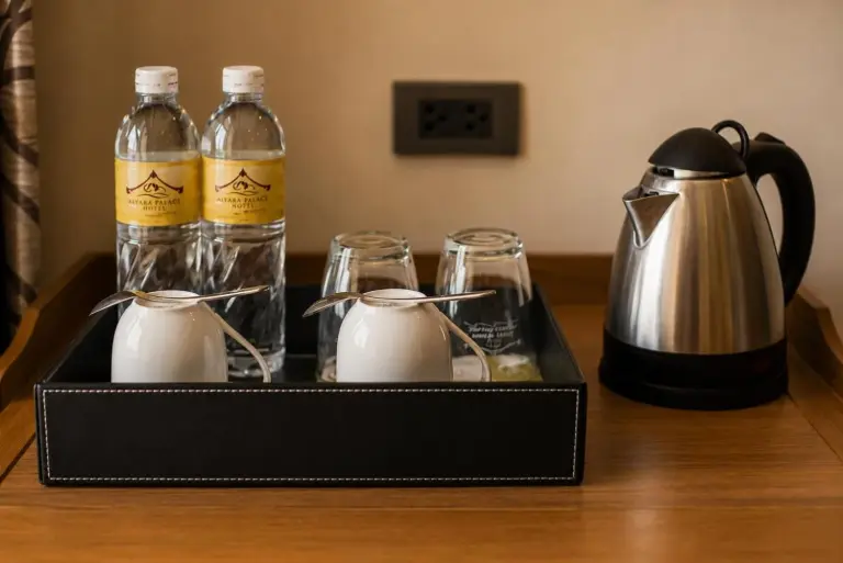 Servicios de café y té en la habitación en Aiyara Palace Hotel Pattaya con botellas de agua y hervidor