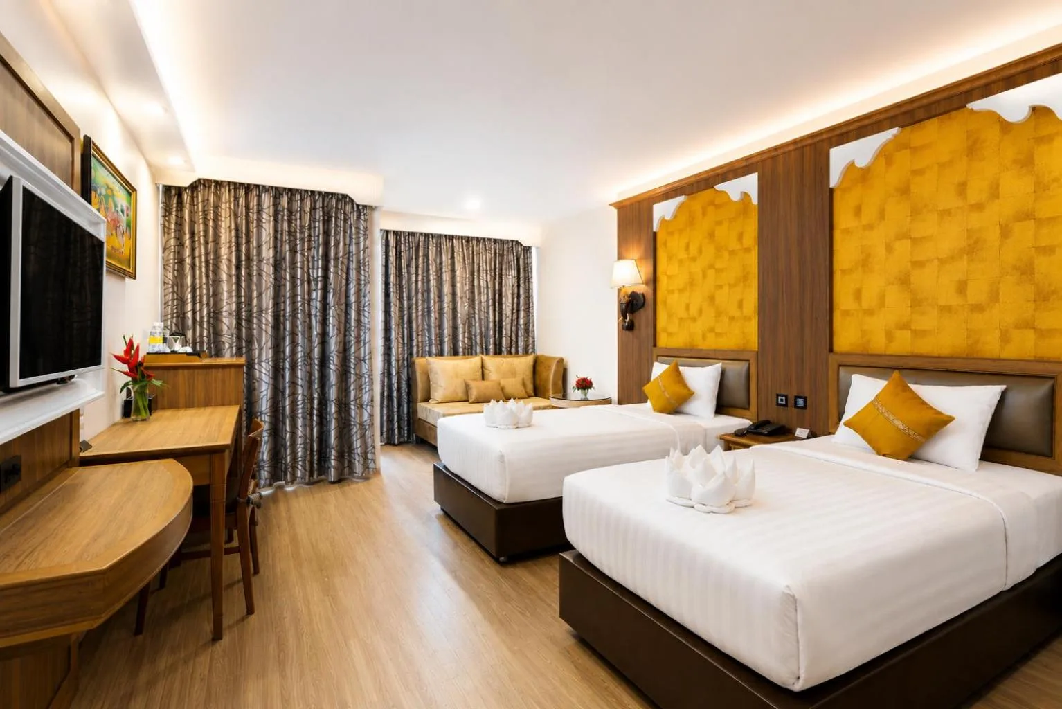 Elegante suite twin en Aiyara Palace Hotel Pattaya con dos camas, TV y zona de estar