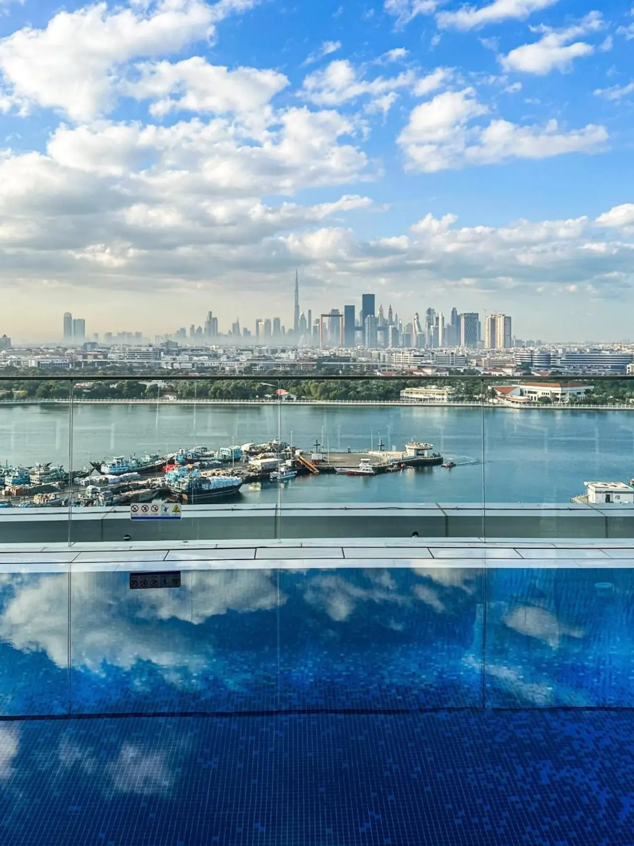 Vista del arroyo y del horizonte de Dubai desde Al Bandar Arjaan by Rotana – Dubai Creek en Dubai con una piscina al aire libre en primer plano