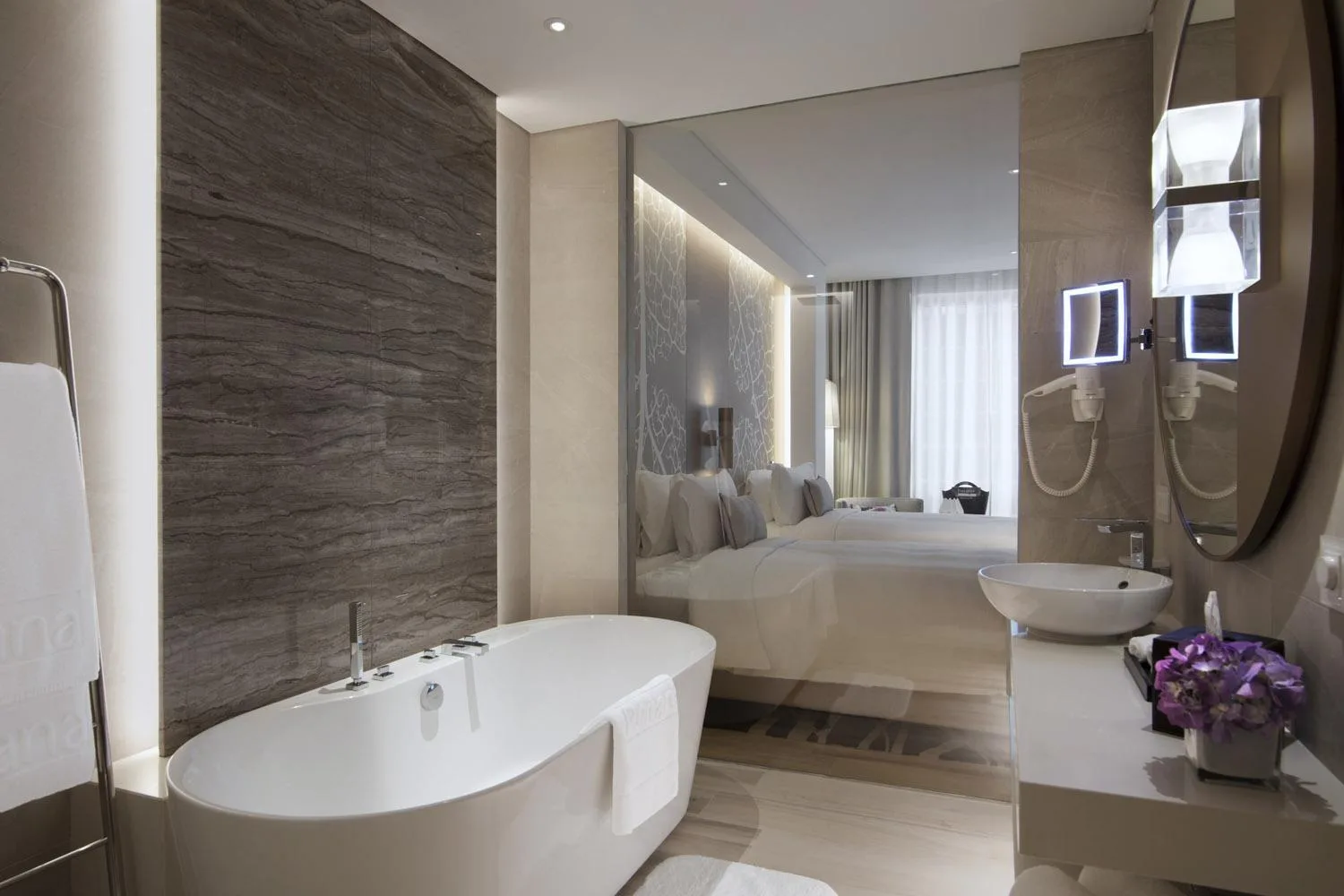 Guest bathroom with bathtub at Al Bandar Rotana – Dubai Creek in Dubai and view through bedroom