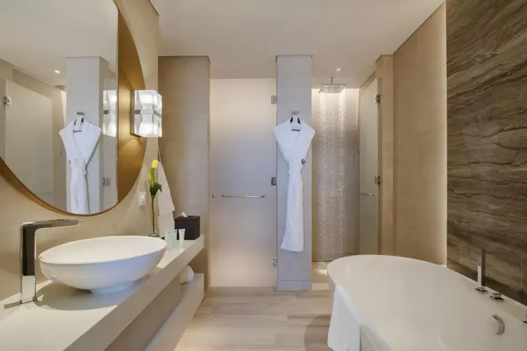 Modern luxury bathroom at Al Bandar Rotana – Dubai Creek in Dubai with bathtub, vessel sink, and robe