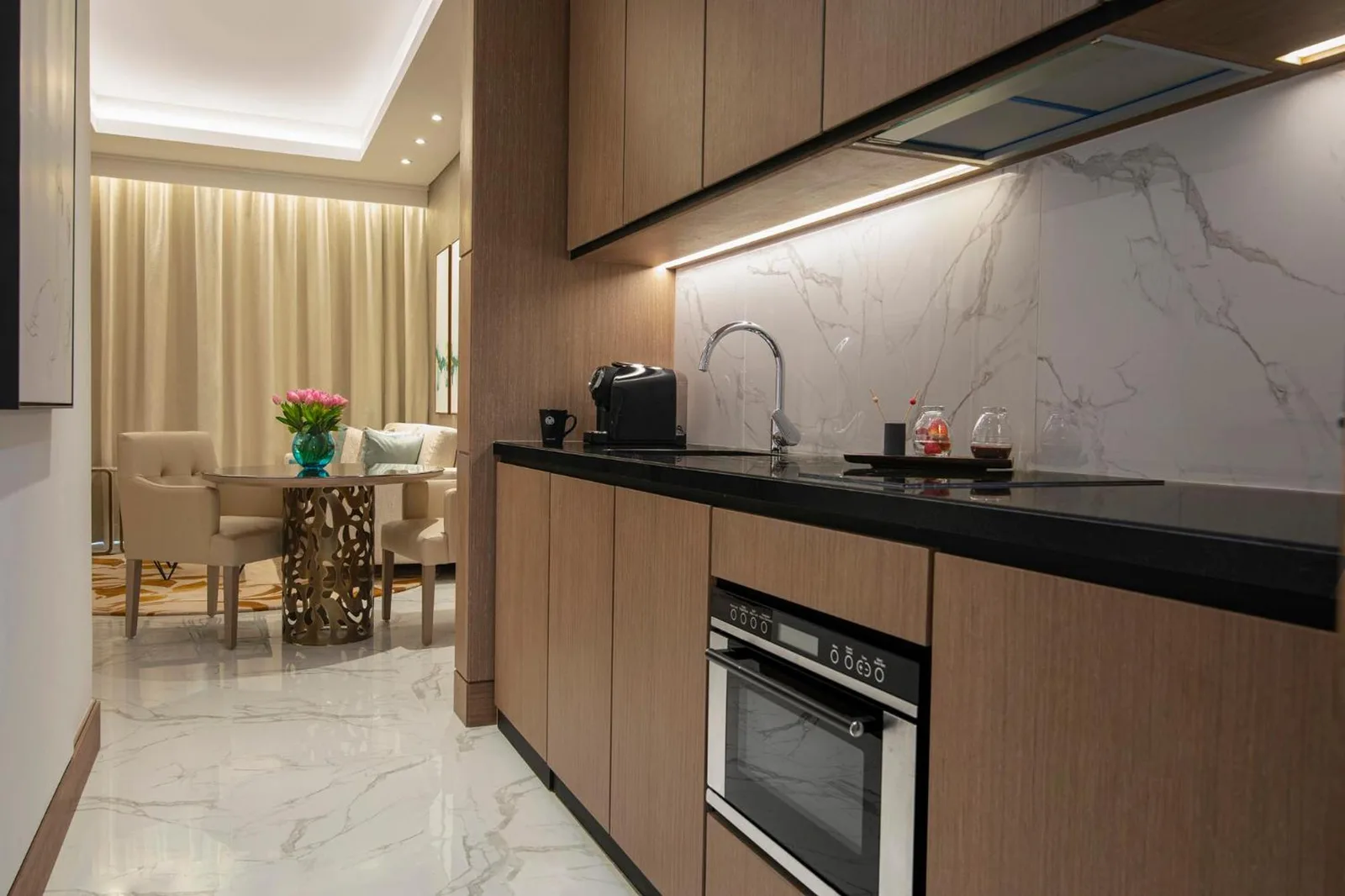 Al Jaddaf Rotana Dubai suite kitchen with built-in appliances, sink, and marble finishes