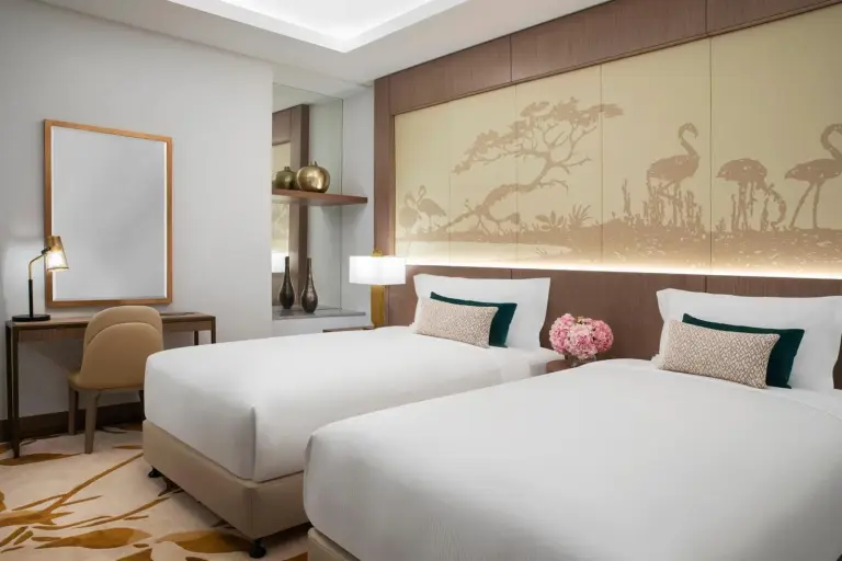 Al Jaddaf Rotana Dubai twin room with two single beds and decorative headboard artwork