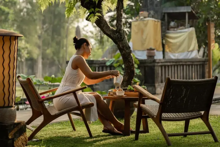 Mujer sirviendo té al aire libre en Alaya Resort Ubud
