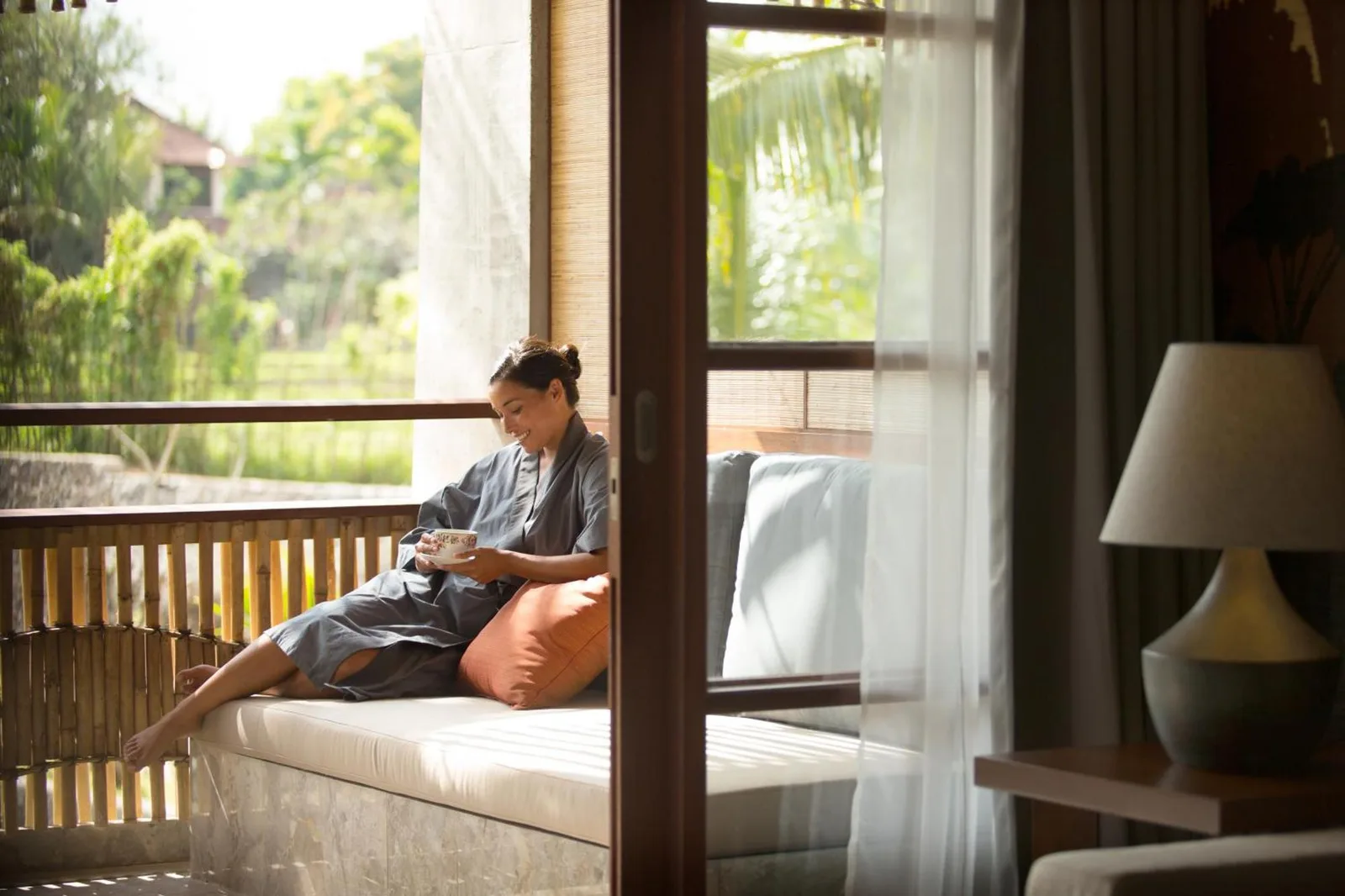 Mujer disfrutando del té en el balcón en Alaya Resort Ubud