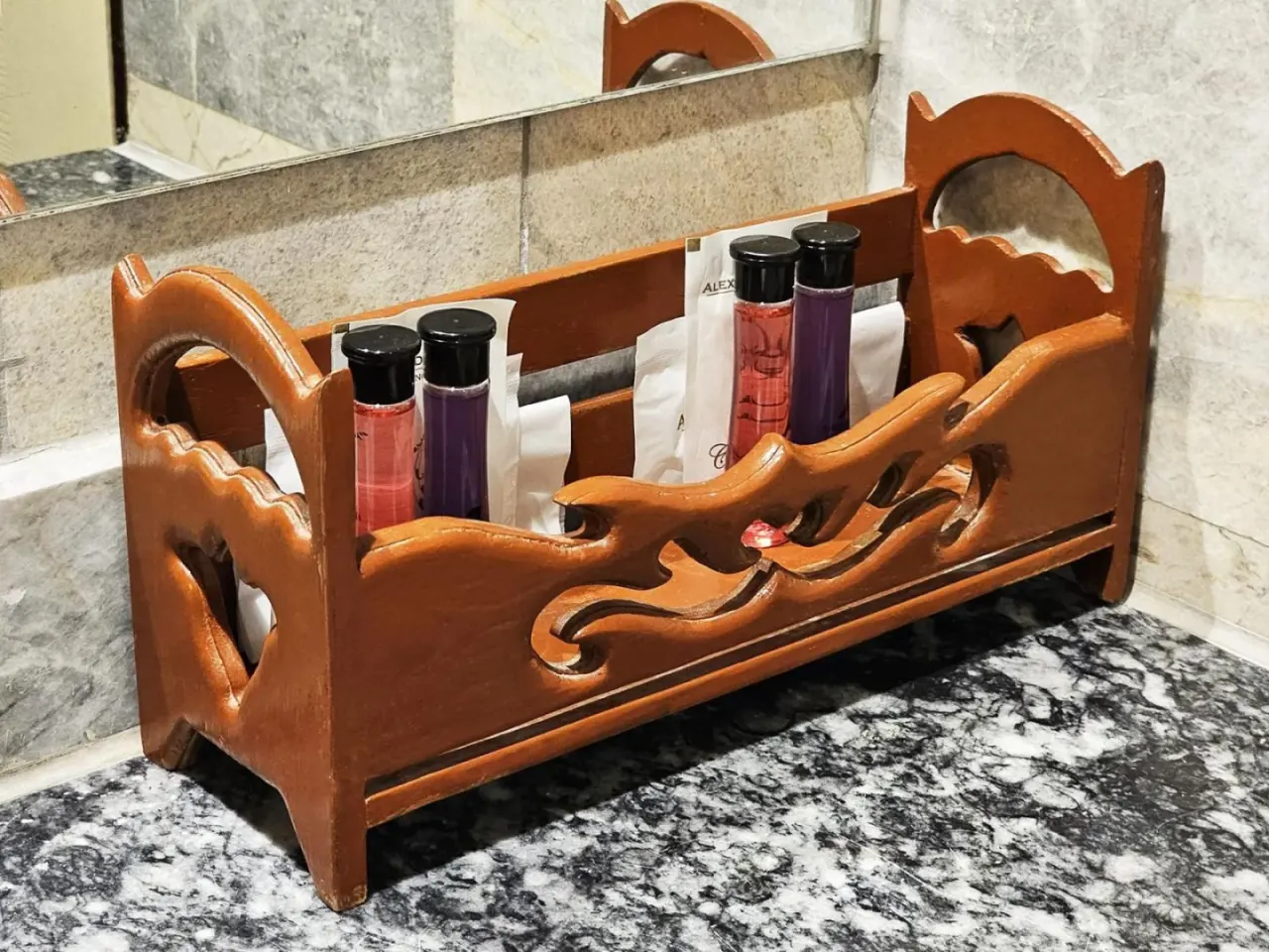 Produits de toilette du Alexander Hotel Bangkok dans un support en bois sur un plan de travail en marbre