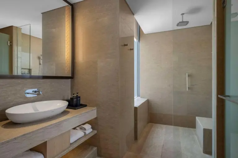 Modern bathroom at Alila Solo hotel in Surakarta with sink, mirror, and walk-in shower
