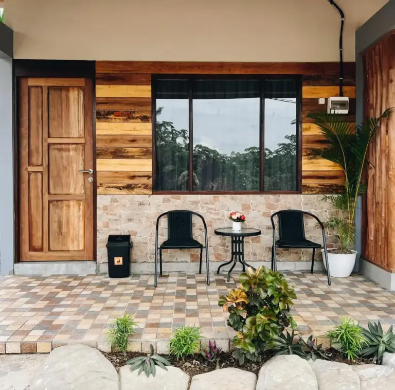 Outdoor patio and room entrance at Amal Zone Villa in Pontianak with wooden facade and seating.