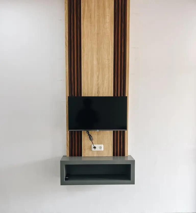 Wall-mounted television and storage shelf inside Amal Zone Villa Pontianak guest room.