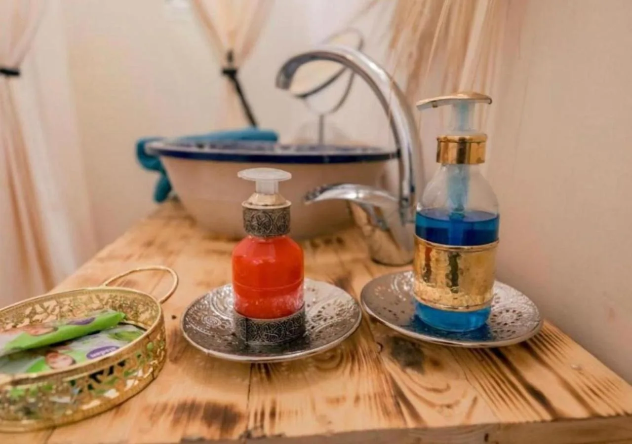 Servicios de baño y zona del lavabo en Amazing Luxury Camp en Merzouga con dispensadores de jabón y un lavabo
