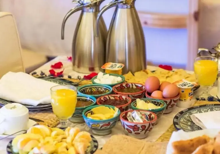 Buffet de desayuno en Amazing Luxury Camp en Merzouga con zumo, huevos, pasteles y varios acompañamientos