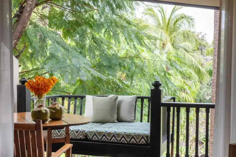 Anantara Bophut Koh Samui Resort – hotel de Koh Samui, Tailandia – un porche con un banco y una mesa con cojines en Anantara Bophut Koh Samui Resort en Bophut