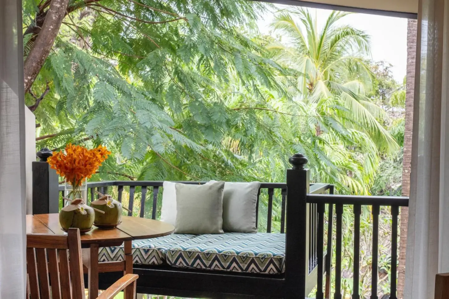 Anantara Bophut Koh Samui Resort – hotel de Koh Samui, Tailandia – un porche con un banco y una mesa con cojines en Anantara Bophut Koh Samui Resort en Bophut