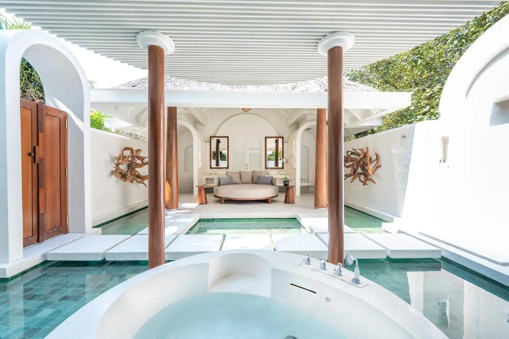 Outdoor jacuzzi area at Anantara Kihavah Maldives Villas with lush privacy.
