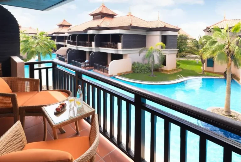 Balcony seating at Anantara The Palm Dubai Resort overlooking the pool.