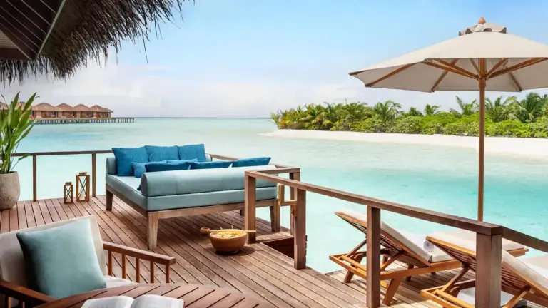 Terraza con asientos y vistas a la playa en Anantara Veli Maldives Resort