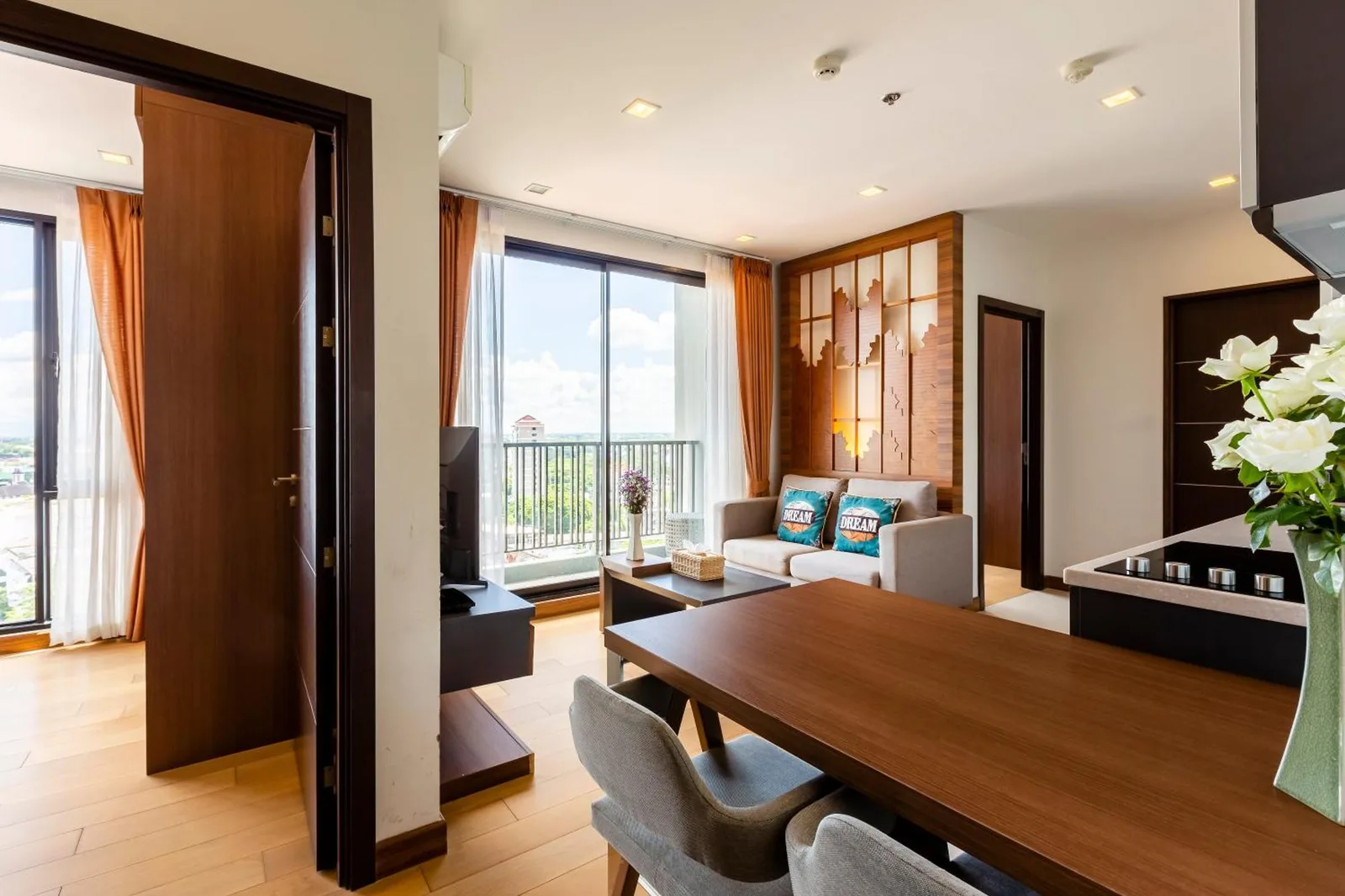 Zona de comedor y sala de estar en Anta Residence Self-service apartment en Chiang Mai con acceso al balcón y vistas a la ciudad