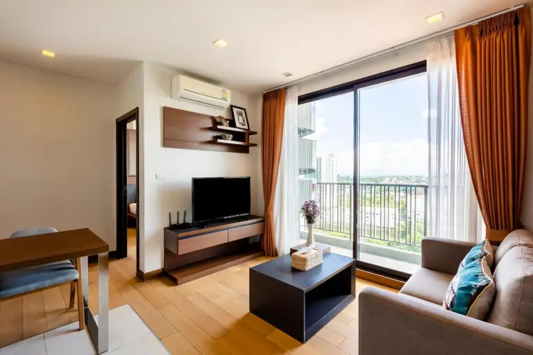 Amplio salón en Anta Residence Self-service apartment en Chiang Mai con TV, balcón y sofá