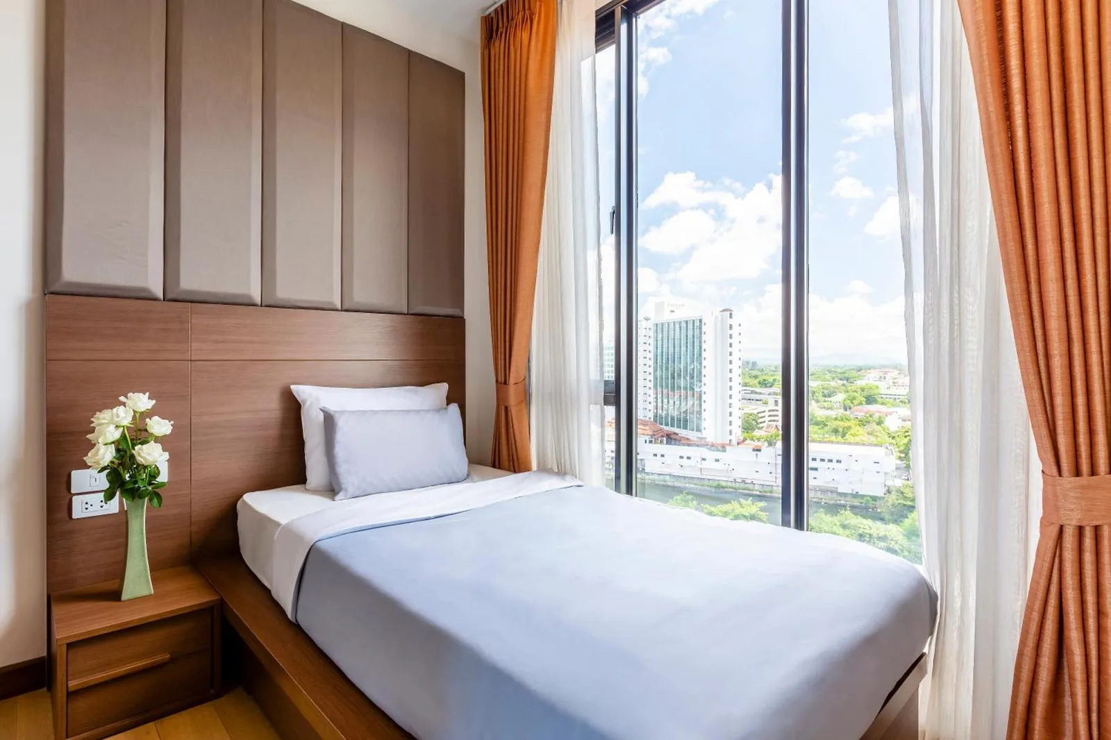 Dormitorio individual compacto en Anta Residence Self-service apartment en Chiang Mai con ventanales de suelo a techo