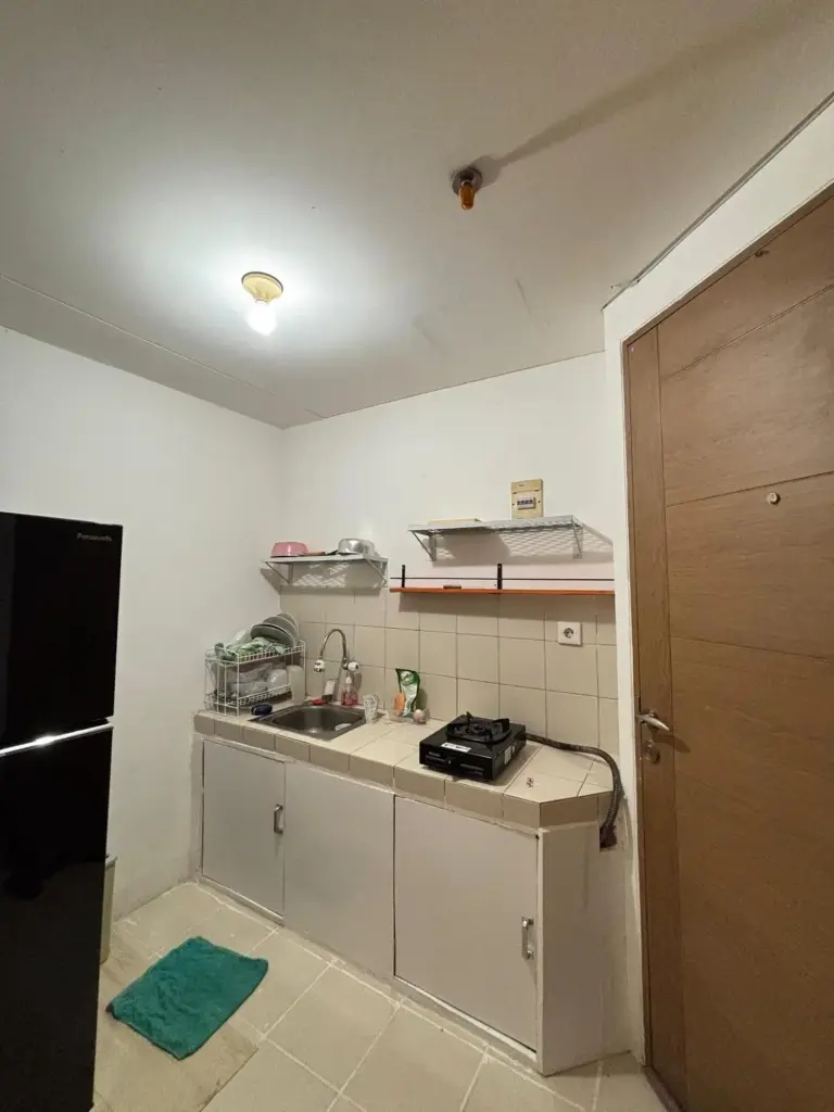 Kitchenette compacte à l’intérieur de Apartemen Cantik 2BR-7 orang Kelapa Gading WIFI à Jakarta avec évier, cuisinière, placards et réfrigérateur.