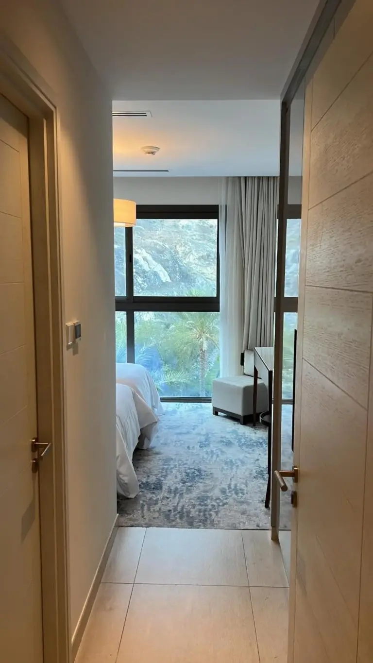 Flur, der zu einem Schlafzimmer im Address Hotel in Khor Fakkan führt