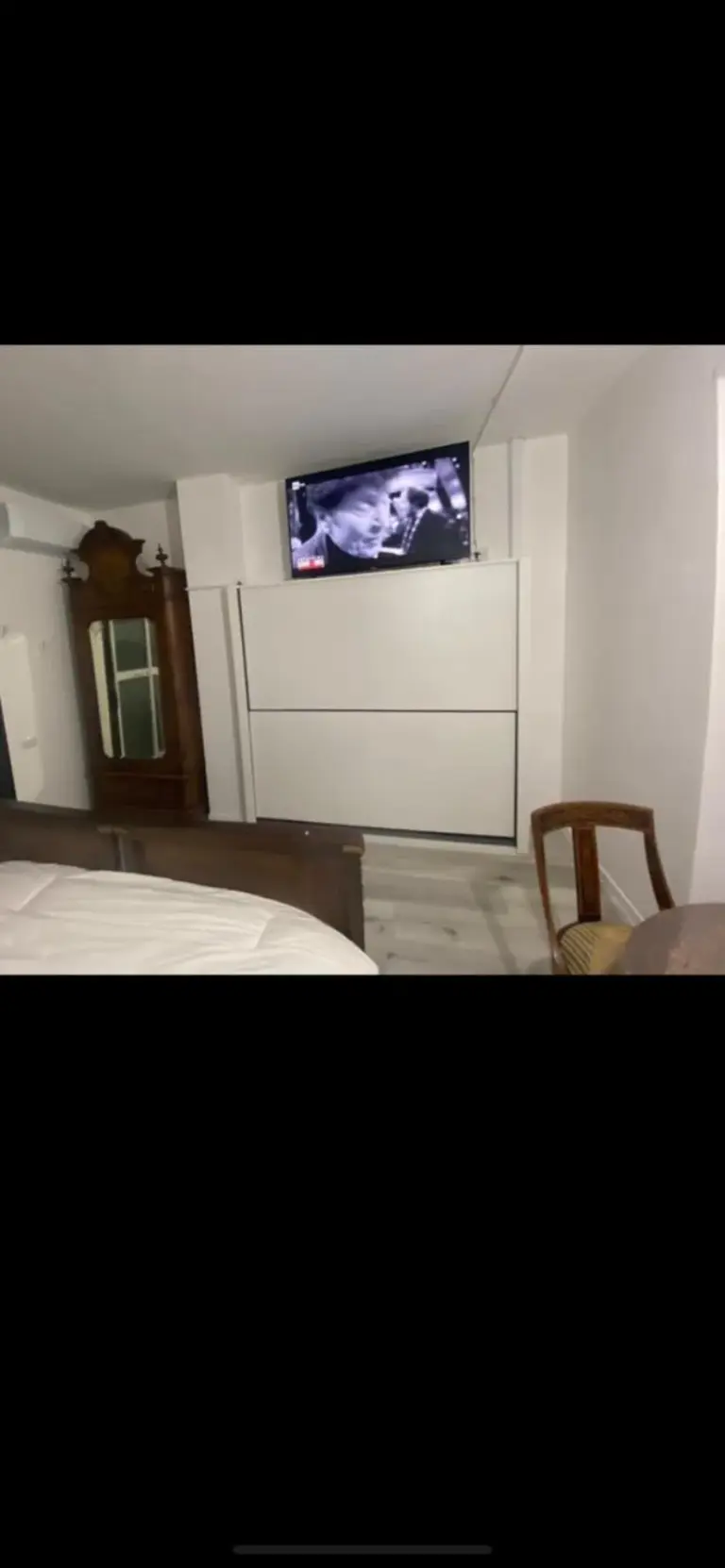Interior clásico del dormitorio en Appartamenti con Terrazzo Solare en Perugia, con cama de madera ornamentada y mesillas de noche