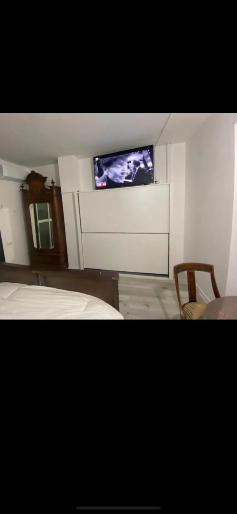 Interior clásico del dormitorio en Appartamenti con Terrazzo Solare en Perugia, con cama de madera ornamentada y mesillas de noche