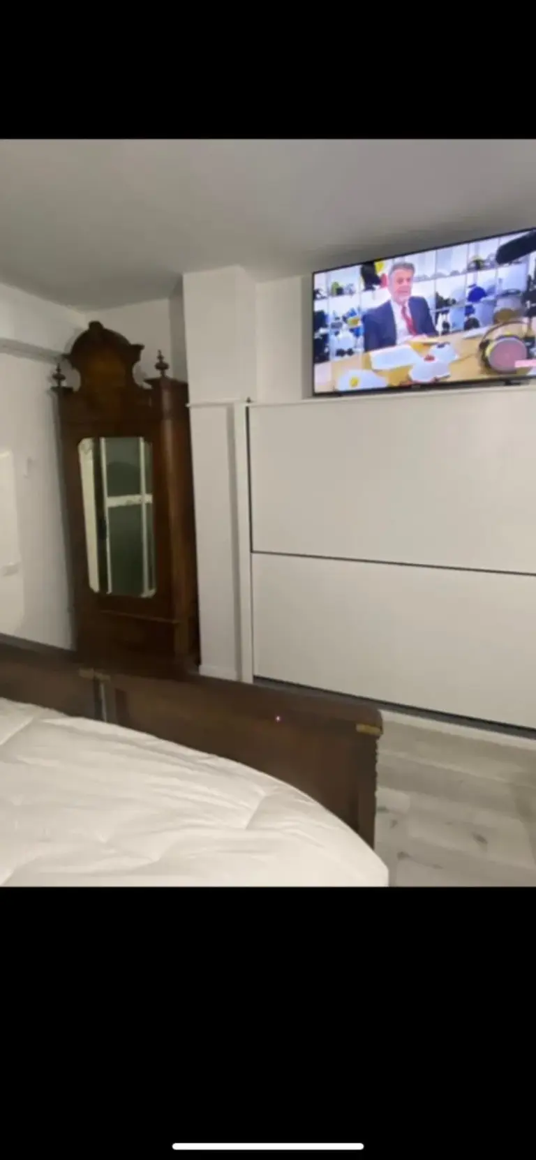 Pared con TV en el dormitorio de Appartamenti con Terrazzo Solare en Perugia, con armario y televisor montado en la pared