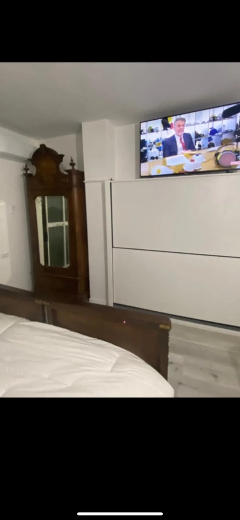 Pared con TV en el dormitorio de Appartamenti con Terrazzo Solare en Perugia, con armario y televisor montado en la pared