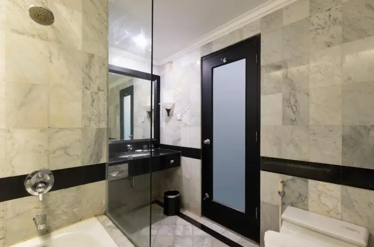 Bathroom at ARTOTEL Suites Aquila Bandung with walk-in shower, vanity, and glass door