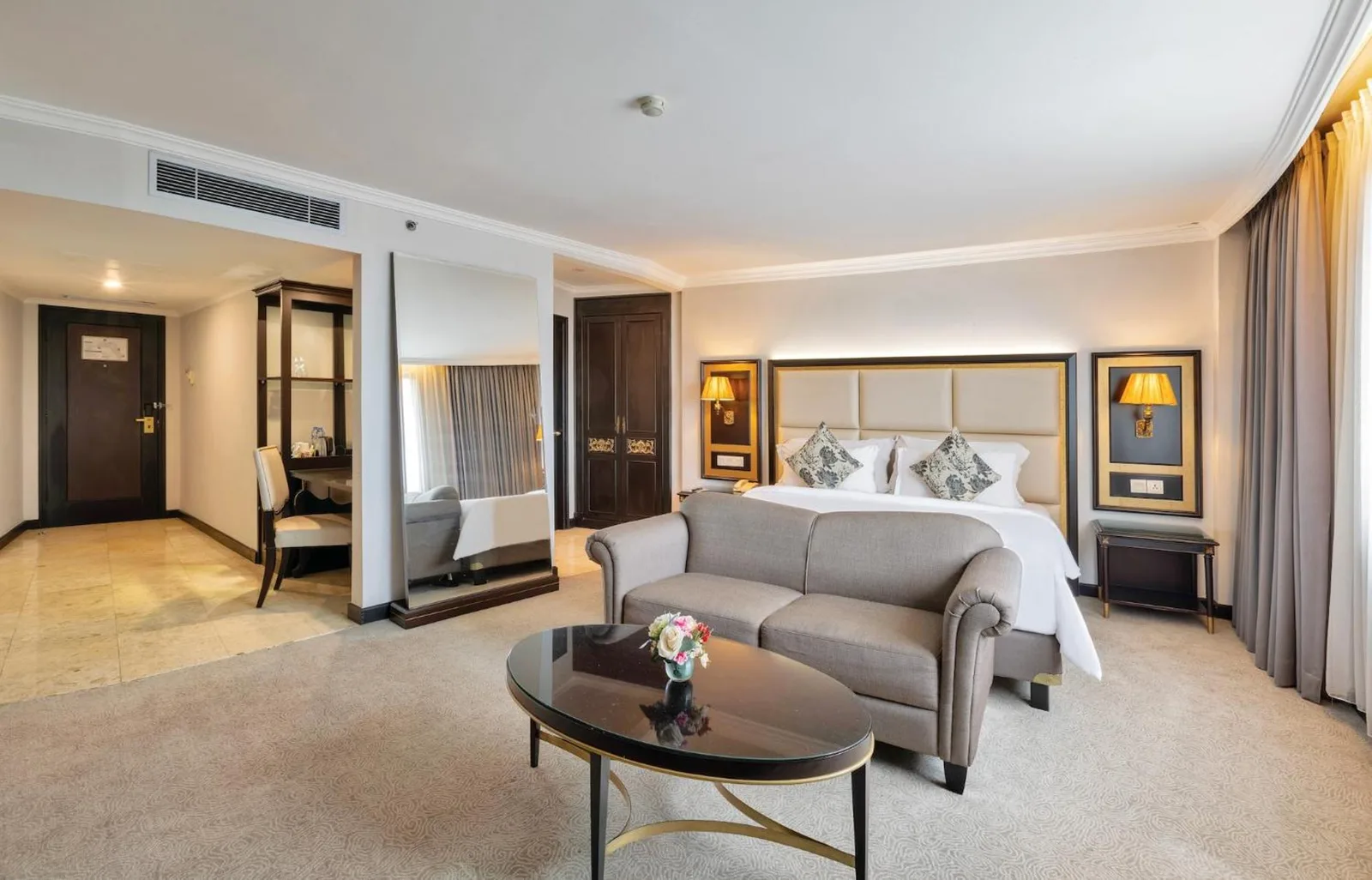 Suite bedroom at ARTOTEL Suites Aquila Bandung with seating area, sofa, coffee table, and double bed