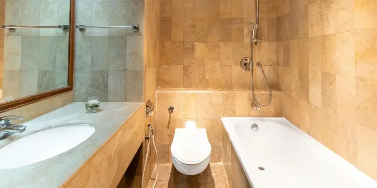 Salle de bains de Aryaduta Menteng à Jakarta avec baignoire, douche, toilettes et lavabo avec meuble vasque.