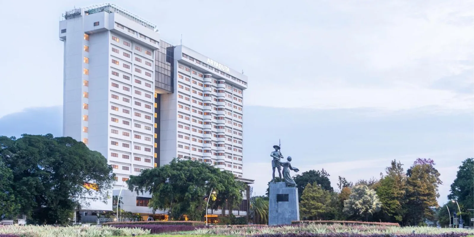 Vue extérieure de Aryaduta Menteng à Jakarta avec la tour de l’hôtel et des jardins paysagers.