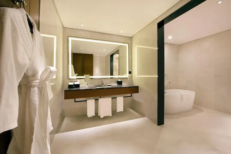 Asiana Grand Hotel Dubai King Suite mit einem großen Bett, Sitzbereich und Minibar-Schrank