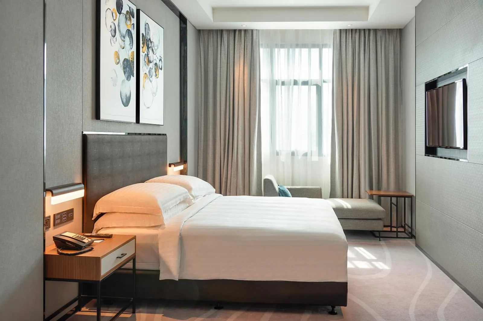 Asiana Grand Hotel Dubai Twin Room mit zwei Betten, einem Sitzbereich und einem wandmontierten Fernseher