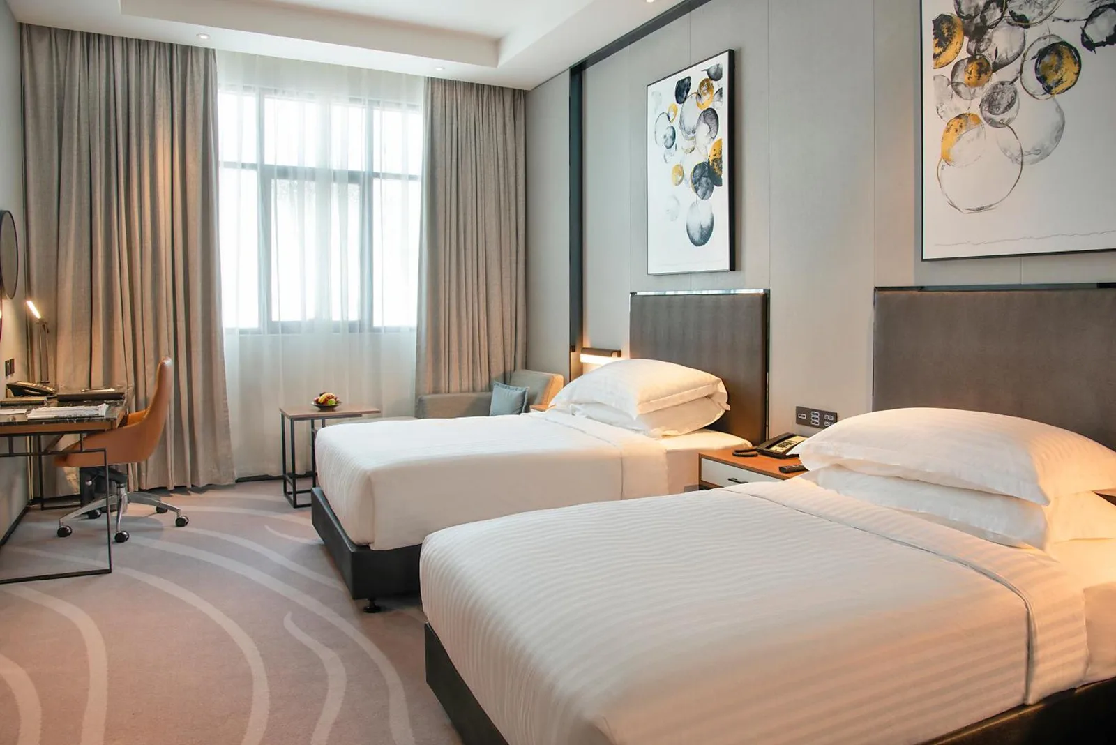 Asiana Grand Hotel Dubai Twin Suite mit zwei Betten, einem Schreibtisch und Tageslicht durch große Fenster