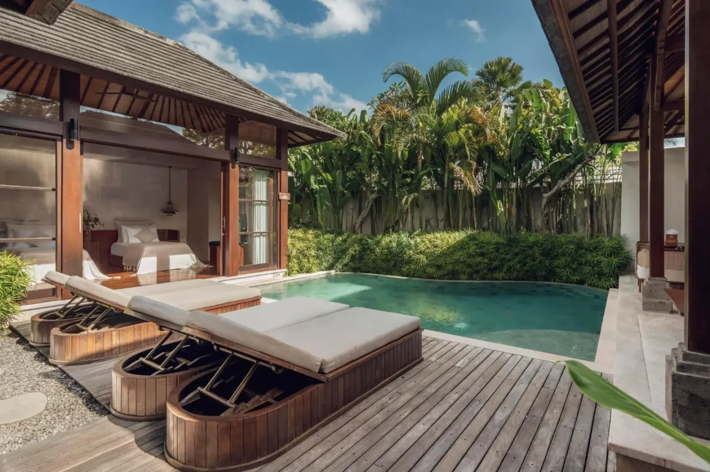 Tumbonas junto a la piscina en Asvara Villa Ubud by Ini Vie Hospitality