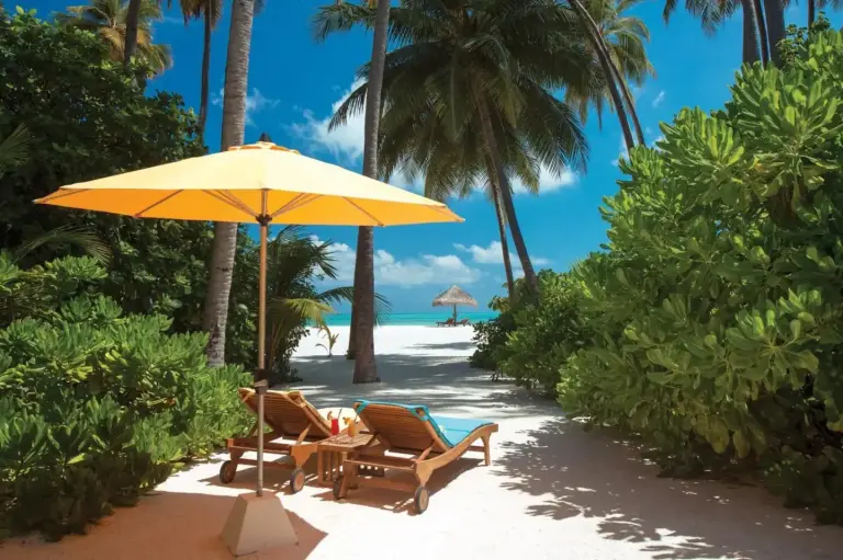 Strandliegen mit einem Sonnenschirm im Atmosphere Kanifushi
