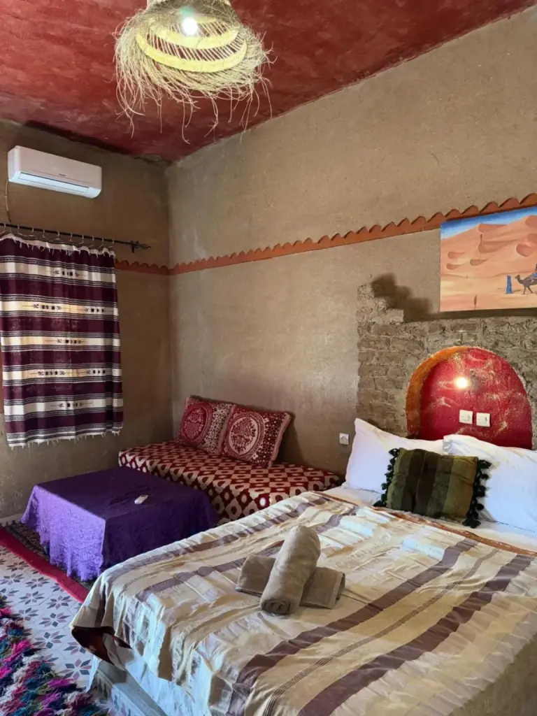 Chambre Double à Auberge Camping La Libertè à Merzouga avec un lit, un canapé et une décoration marocaine traditionnelle
