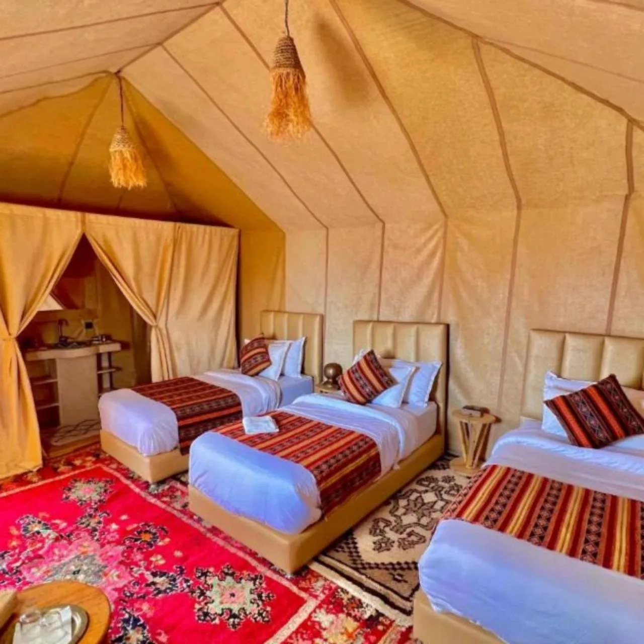 Aurea Duna Luxury Camp – Merzouga, Morocco hotel – a room with two beds with blue shirts on them at Aurea Duna Luxury Camp in Merzouga