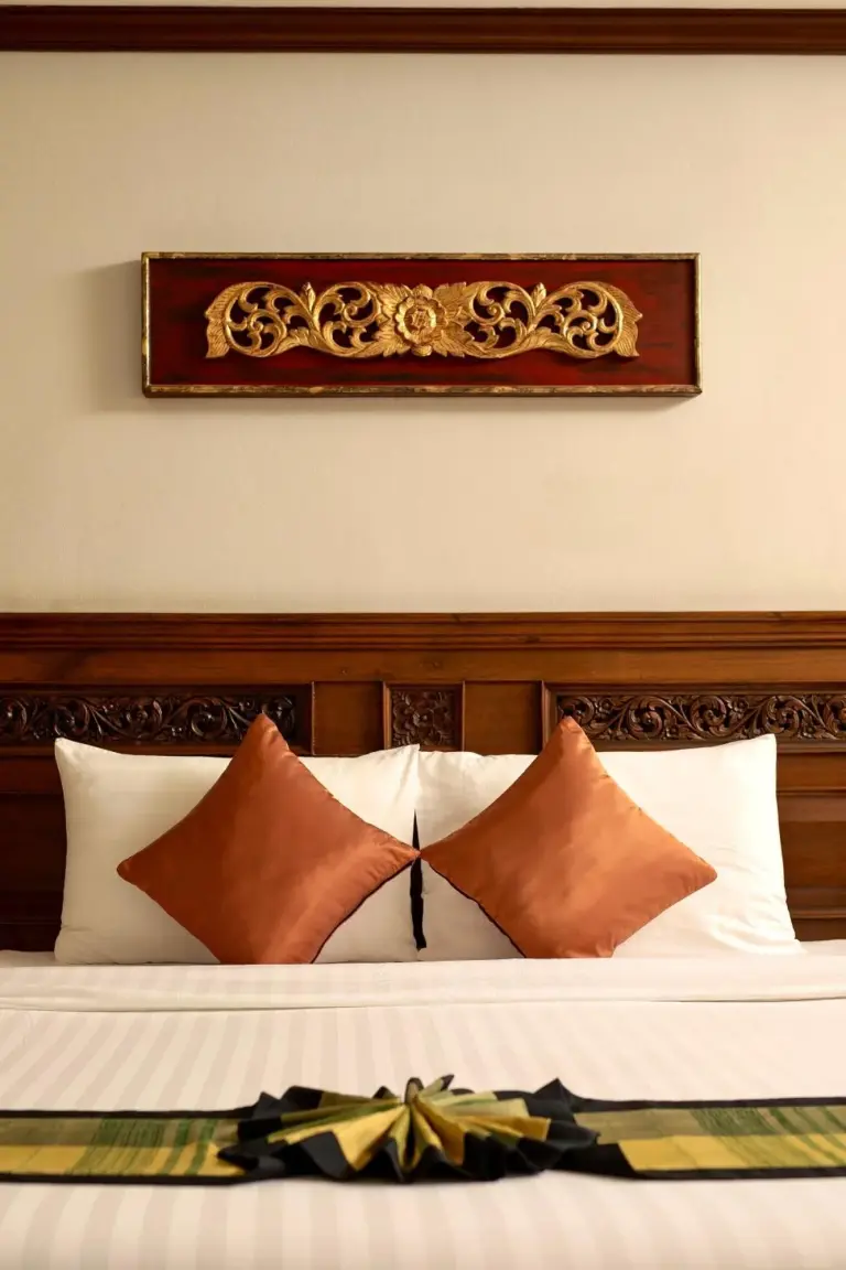 Primer plano de la cama y el cabecero decorativo en una habitación de Avalon Beach Resort Pattaya, Pattaya.