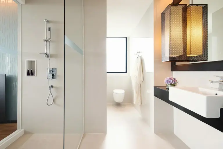 Elegant bathroom at Avani Khon Kaen Hotel & Convention Centre with walk-in shower, sink, and separate toilet area.