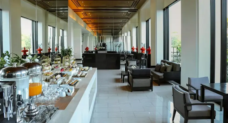 Restaurant dining area at Avani Khon Kaen Hotel & Convention Centre with buffet setup and seating by the windows.