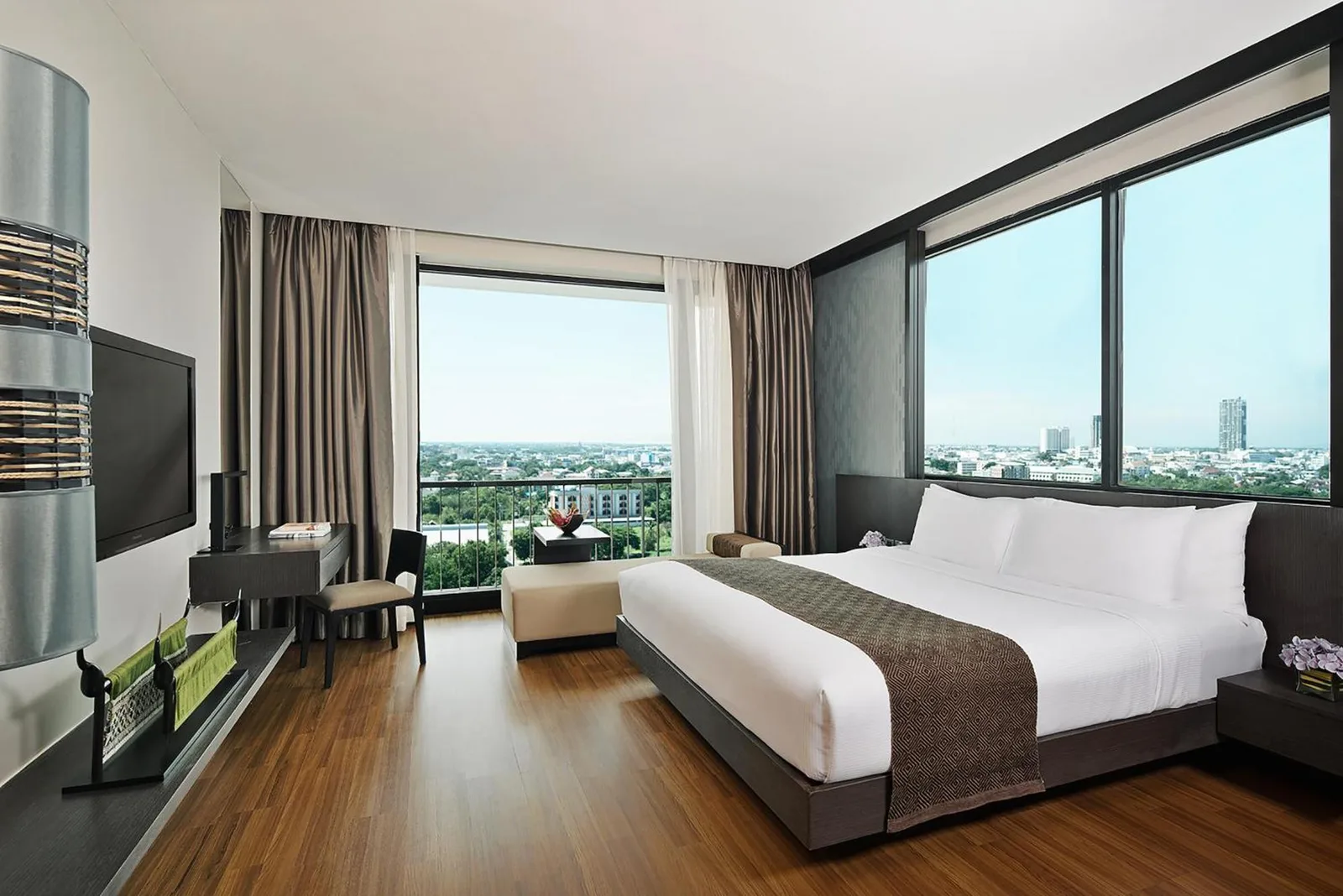 Suite room at Avani Khon Kaen Hotel & Convention Centre with king bed, panoramic windows, and city view.