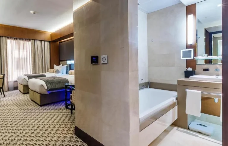 Ayla Grand Hotel – Al Ain, Vereinigte Arabische Emirate Hotel – ein Hotelzimmer mit zwei Betten, einem Schreibtisch und einem Fernseher im Ayla Grand Hotel in Al Ain
